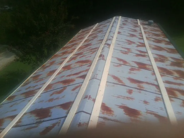 Rusted metal roof panels with new wood purlins before replacement — Storm Damage Roof Repair in Lee by Roofing Brothers